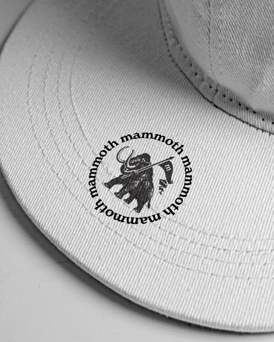 A white cap embroidered with the Mammoth roundel